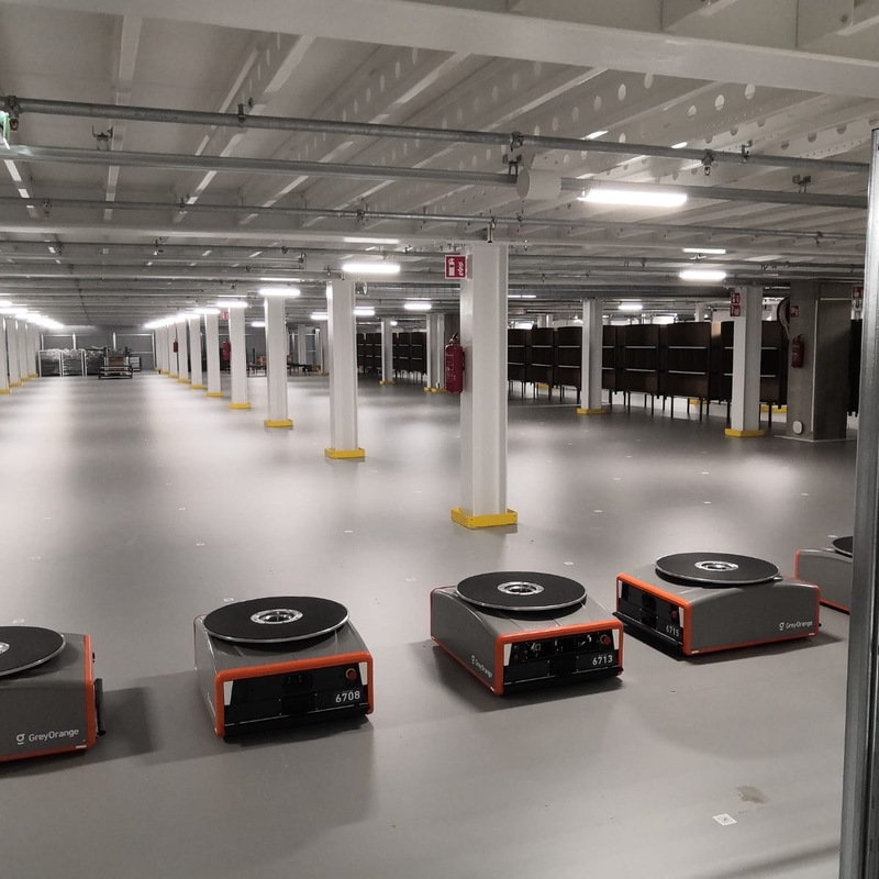 Keräilyrobotteja rivissä välitasolla automaattisessa varastojärjestelmässä.