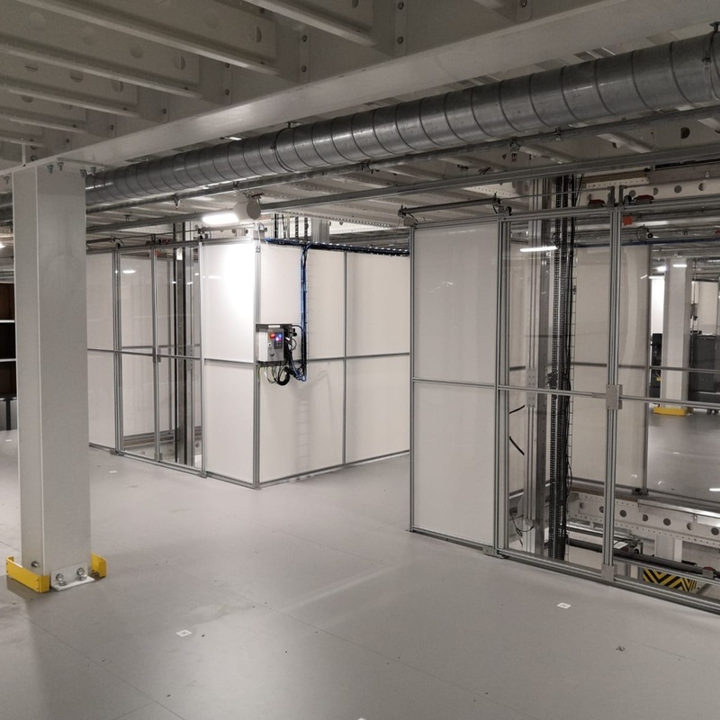 Automaattihissi siirtämässä keräilyrobotteja välitasojen välillä varastoautomaatiossa.