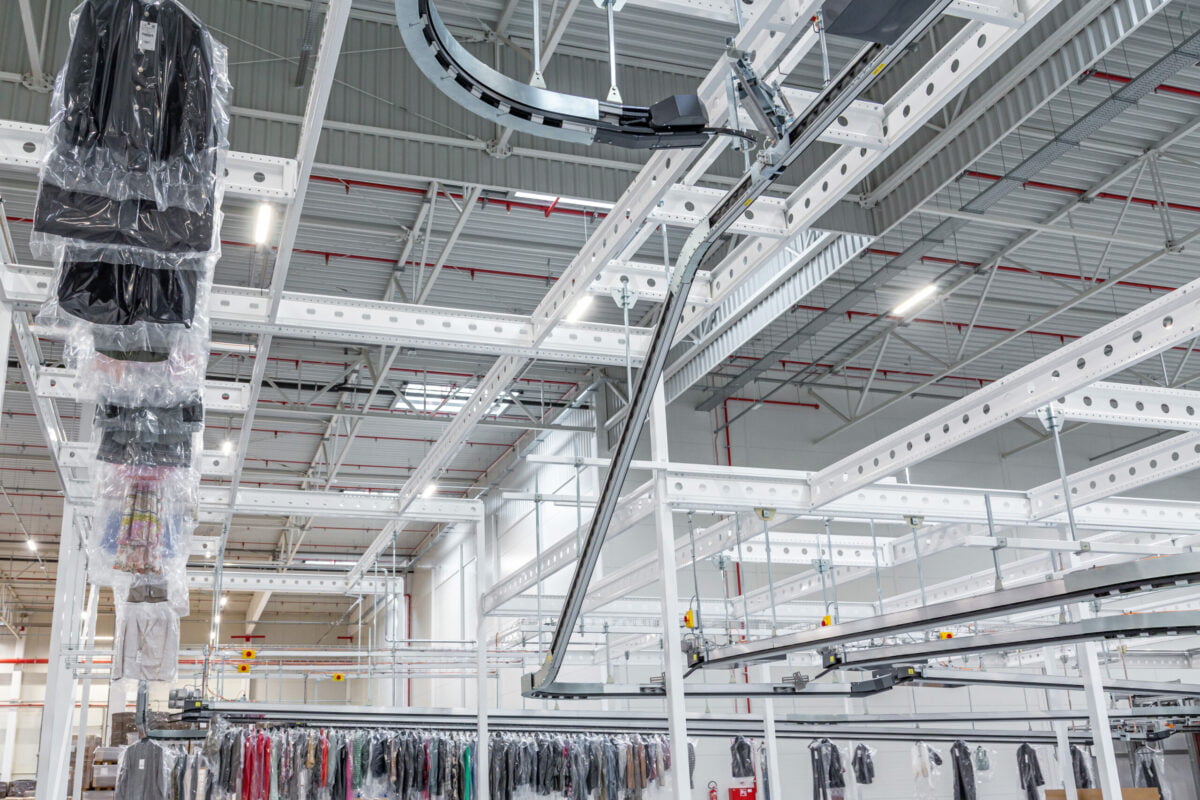 Overhead garment conveyors delivering hanging garments to a different stock floor to be further sorted.